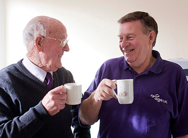 An older man and an ϲʿֱstaff member share a cup of tea